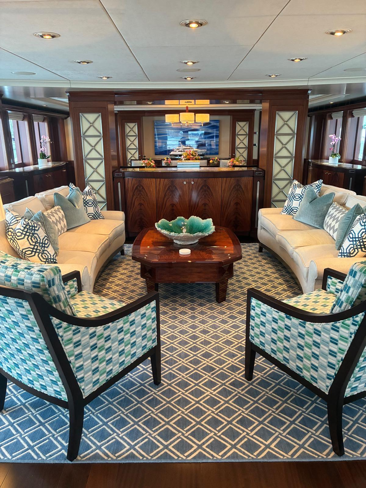 Main salon of motor yacht Avalon — facing sofas, high-gloss joinery and a marble-topped bar